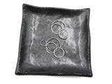 Earrings displayed on a black ceramic tray for visual impact